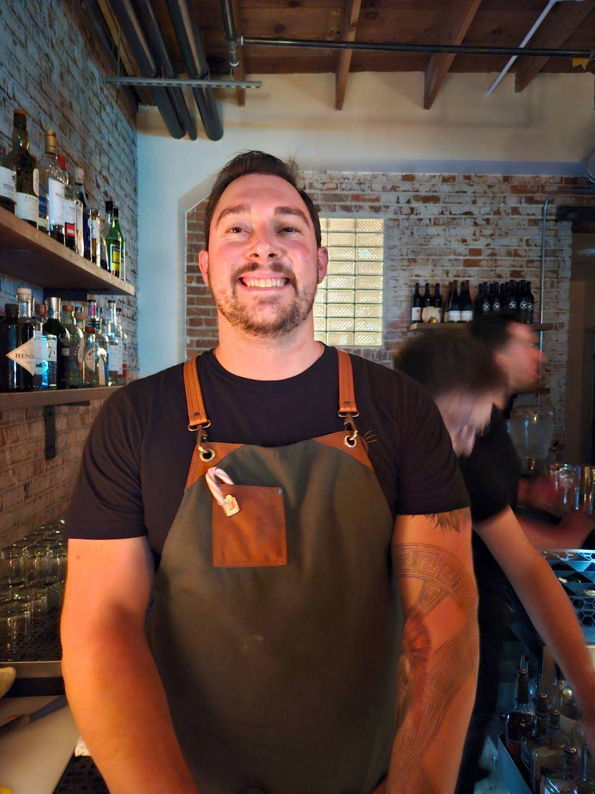 Bartender smiling in brick bar interior